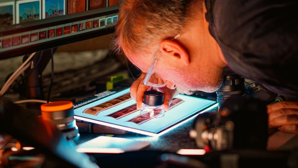 An ASE-certified master technician underneath a lifted pickup truck in a Tire Town service bay.